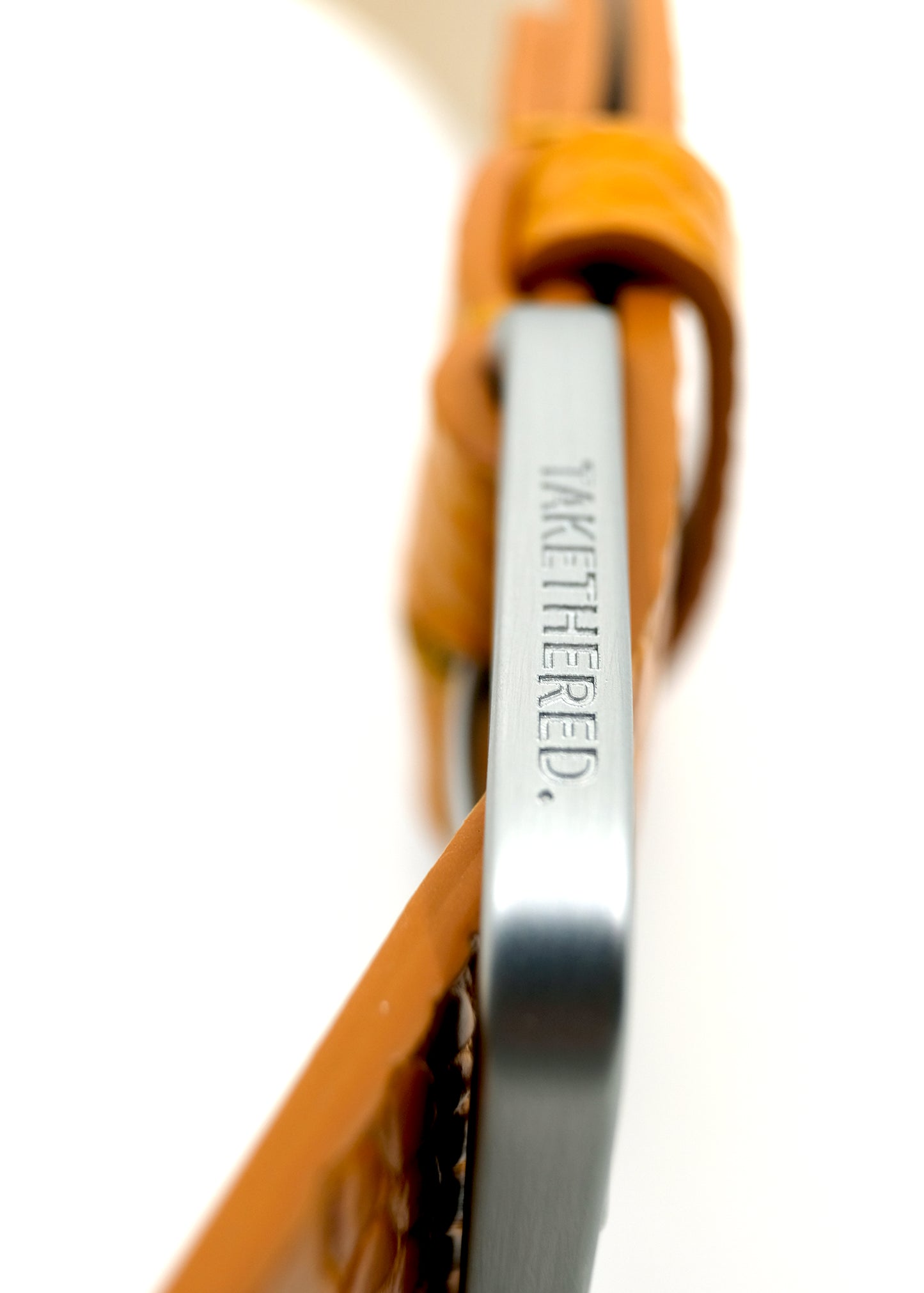 Side view of the yellow Mississippi Belt buckle in silver metal, engraved with the "TAKETHERED" brand name.