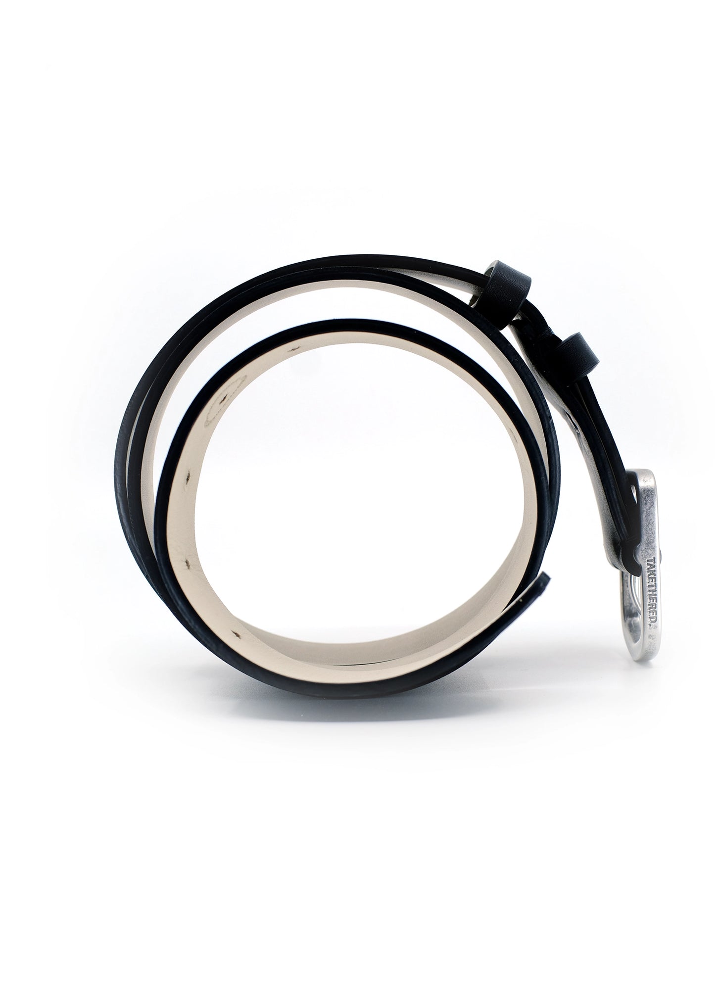 Side view of coiled Classic Pitch Black smooth leather belt with weathered silver buckle and "TAKETHERED." engraving.