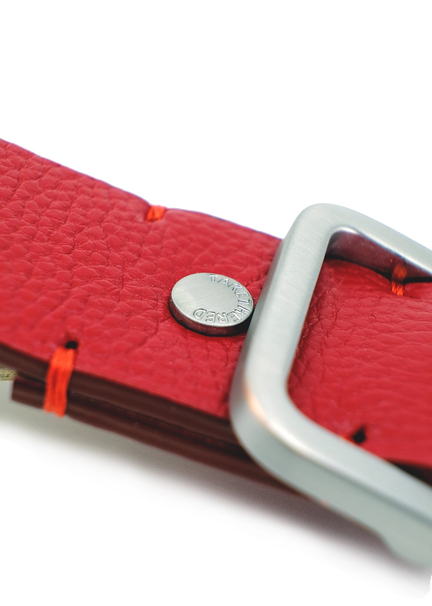 Close-up of Blood Simple Grunge Belt showing red reinforcement stitches and a silver rivet engraved with "TAKETHERED."