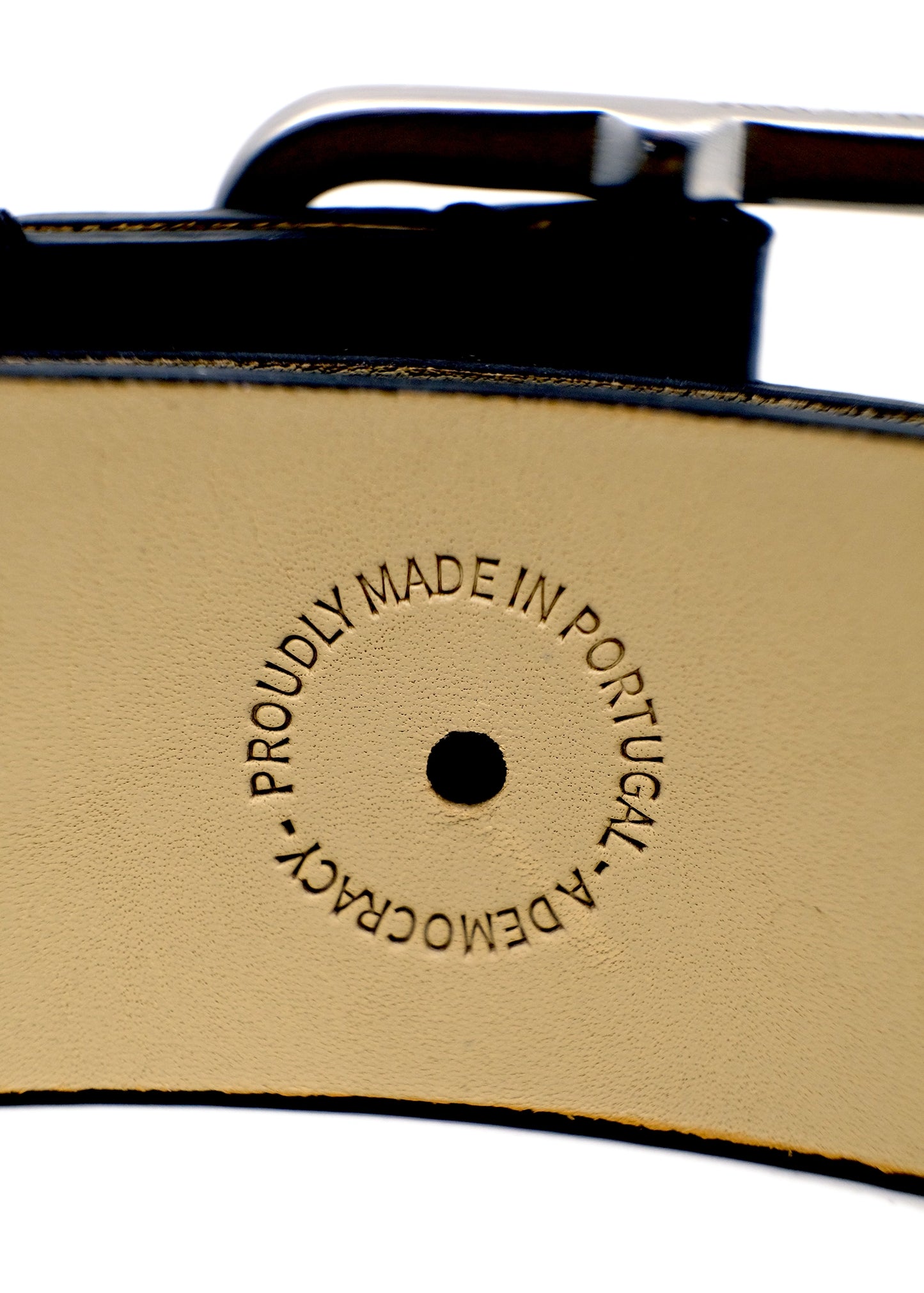 Close-up of the tan belt interior featuring a circular "PROUDLY MADE IN PORTUGAL - A DEMOCRACY" embossed stamp.