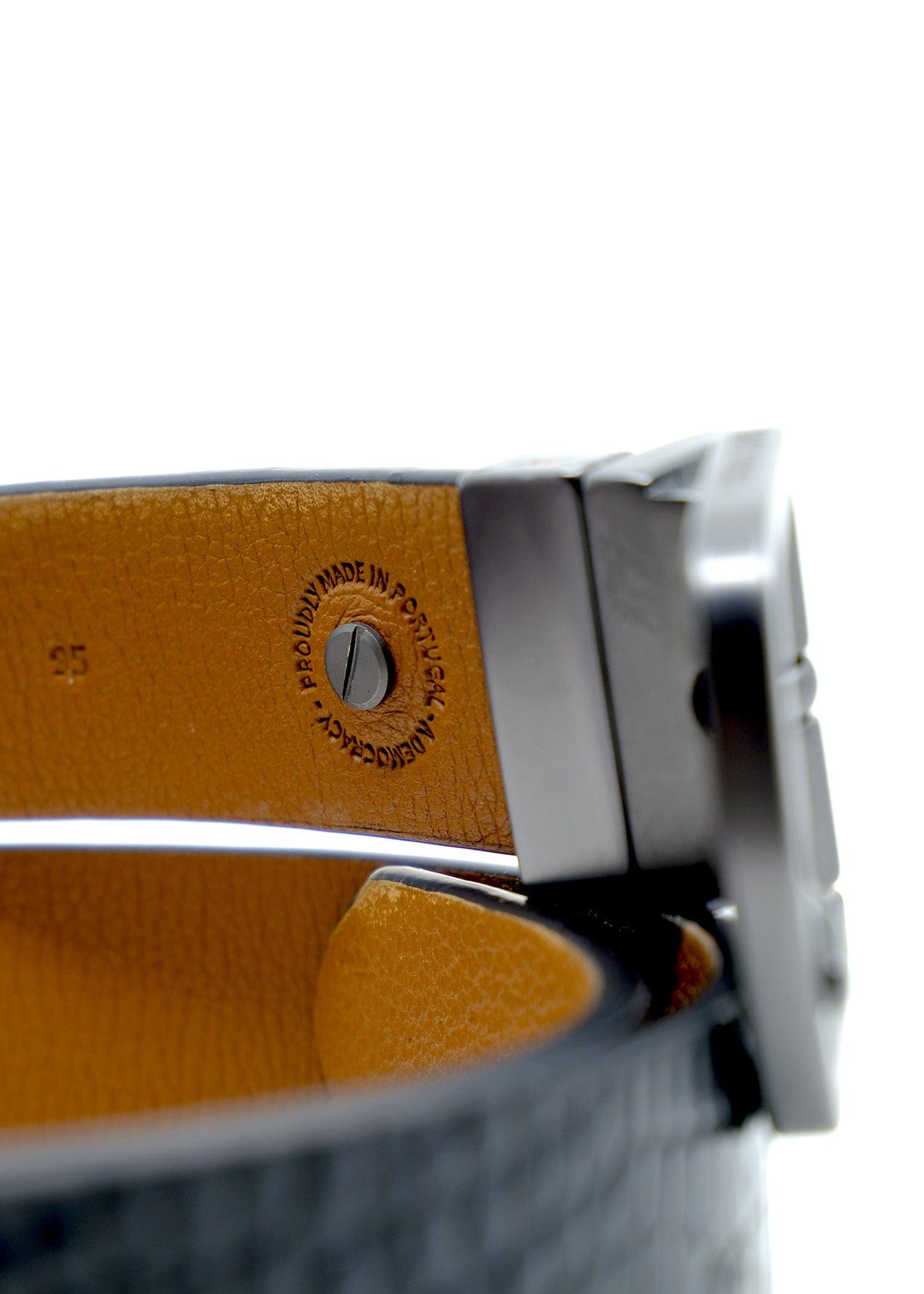 Interior close-up of Two-Face Belt showing the "Proudly Made in Portugal" stamp on Smokey Cognac-grained leather.