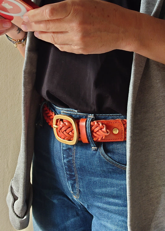 Tatooine Sunset orange braided belt styled with blue jeans, a black t-shirt and a grey cardigan.