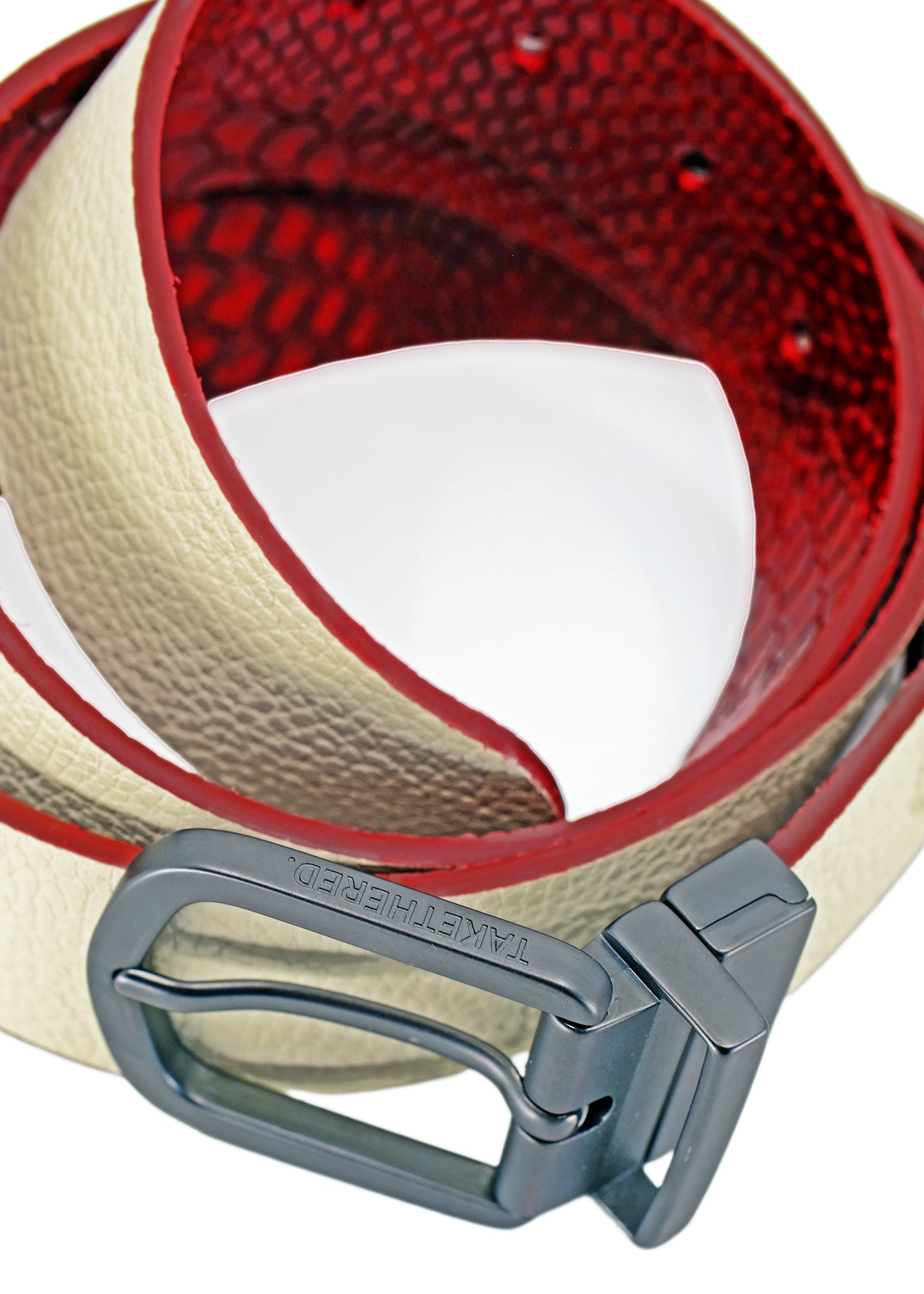 Close-up of the Two-Face belt's reversible black buckle with branding, showing the transition between Desert White leather and the red snakeskin interior.
