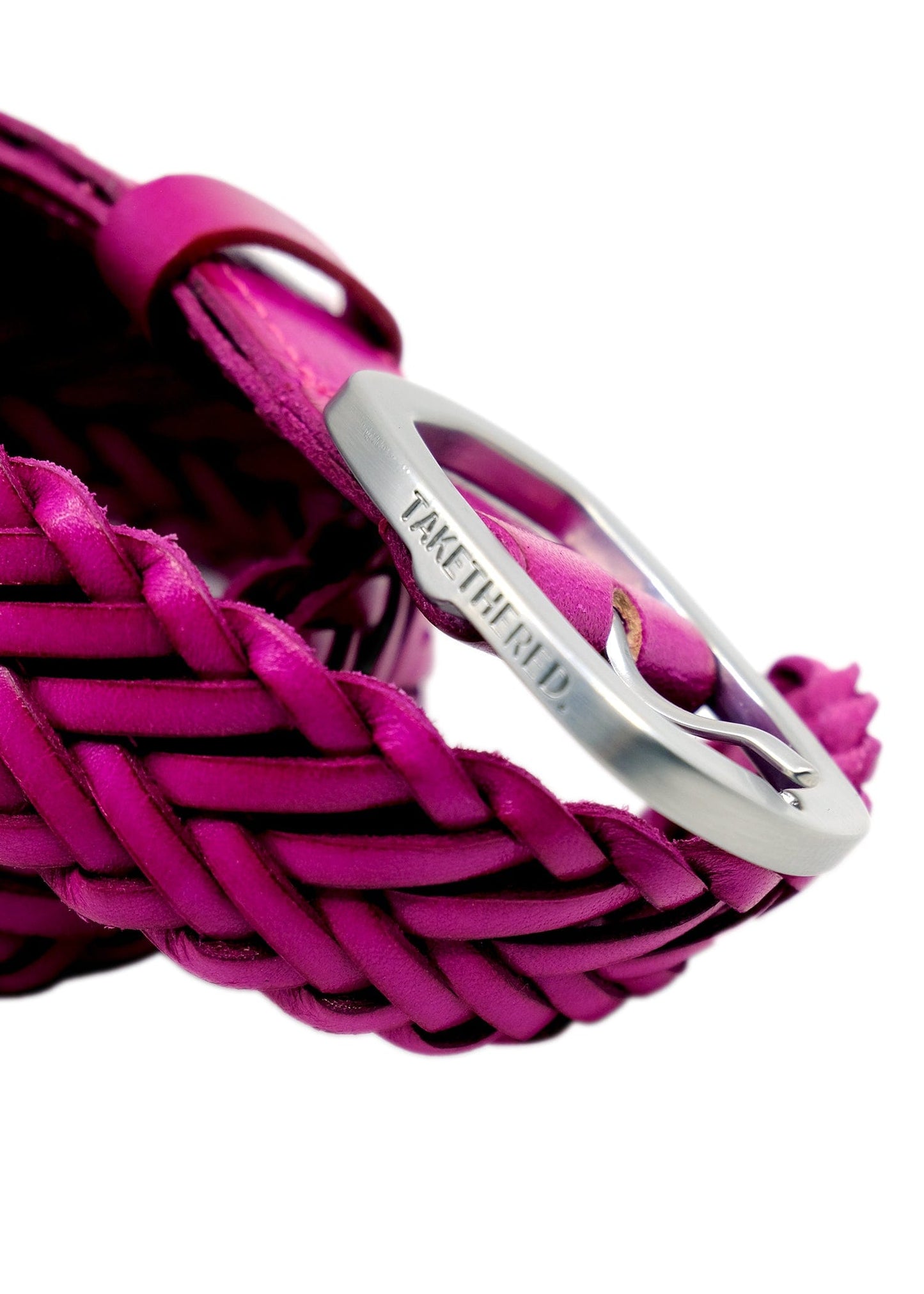 Macro shot of Barbie Pink braided belt with a matte silver buckle featuring an engraved "TAKETHERED." logo.