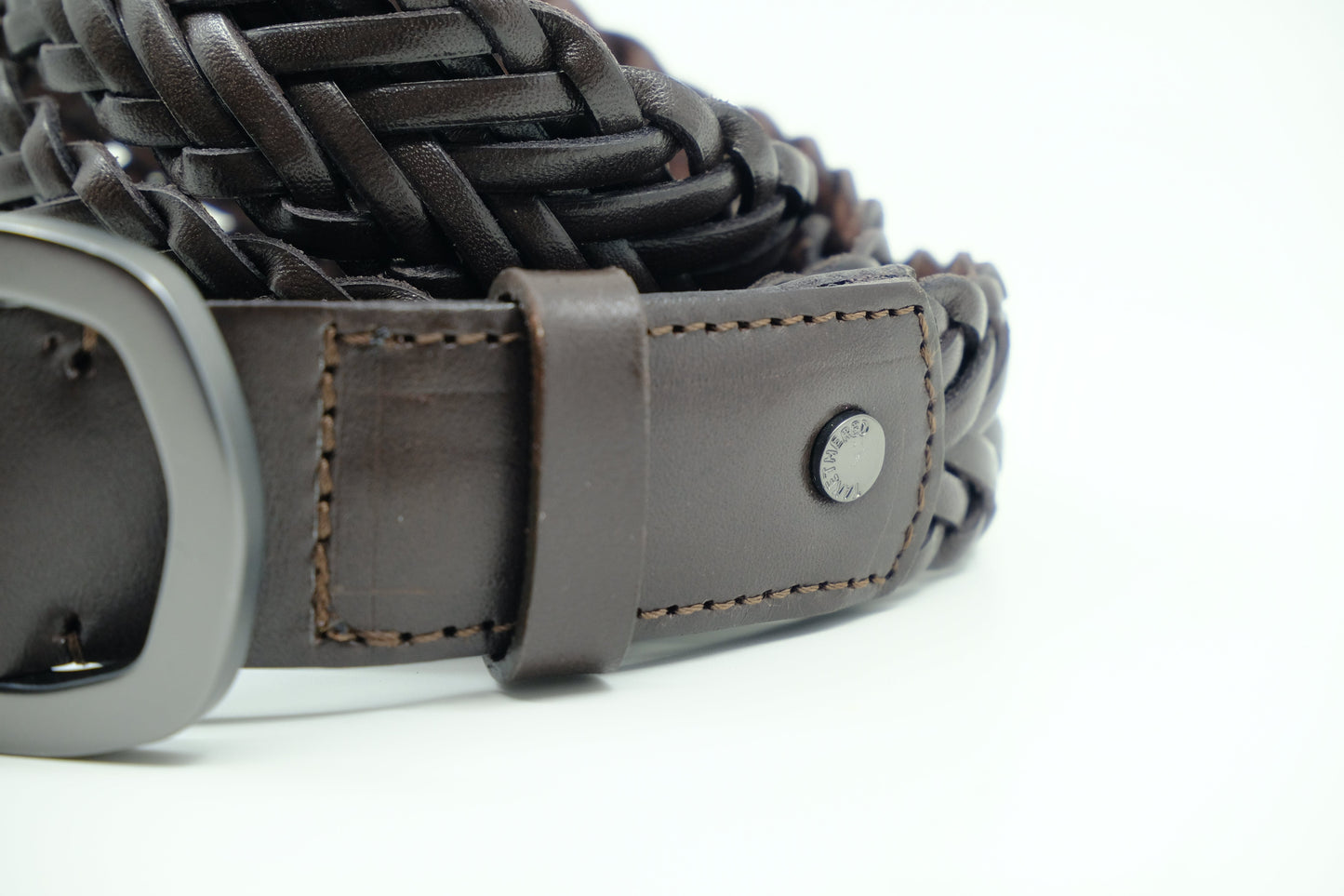 Close-up of Espresso braided leather belt showing brown stitching, a matte black rivet, and the woven texture.
