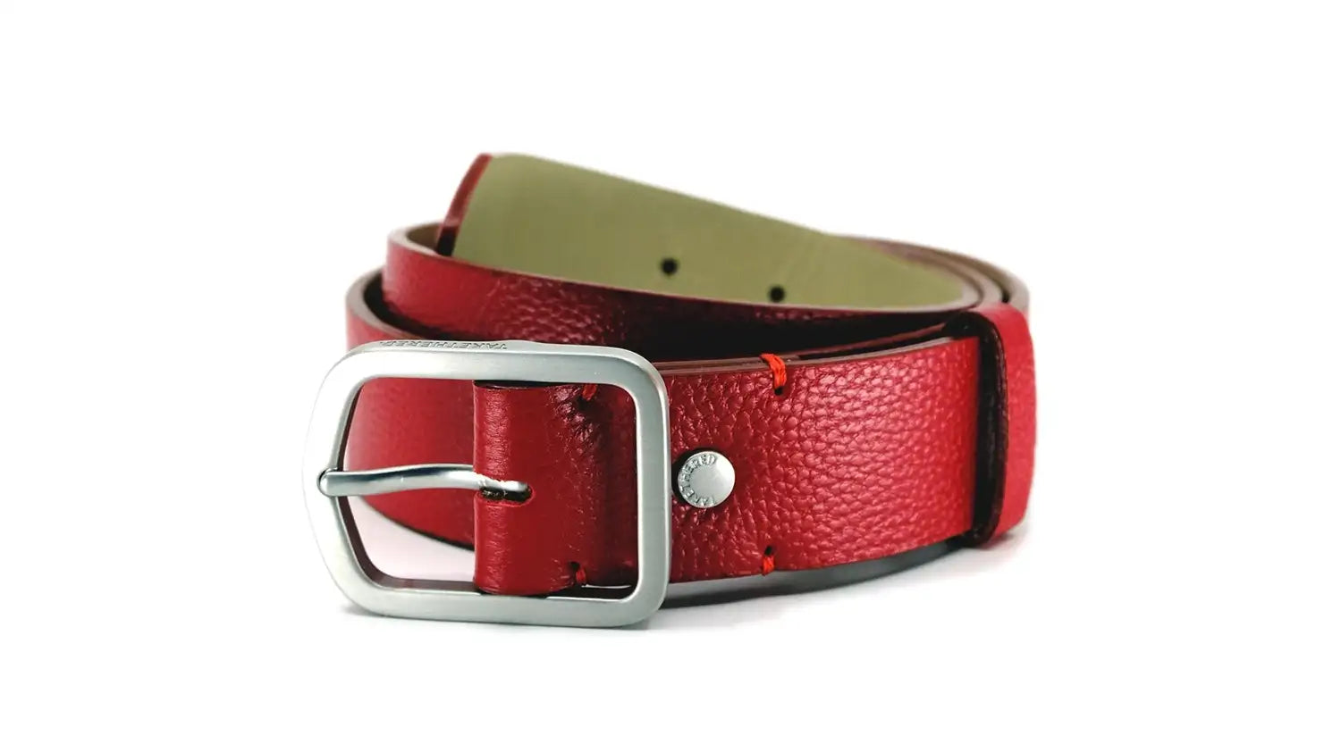 Macro close-up of a grunge leather belt in blood red with a silver buckle and a logo embossed rivet.