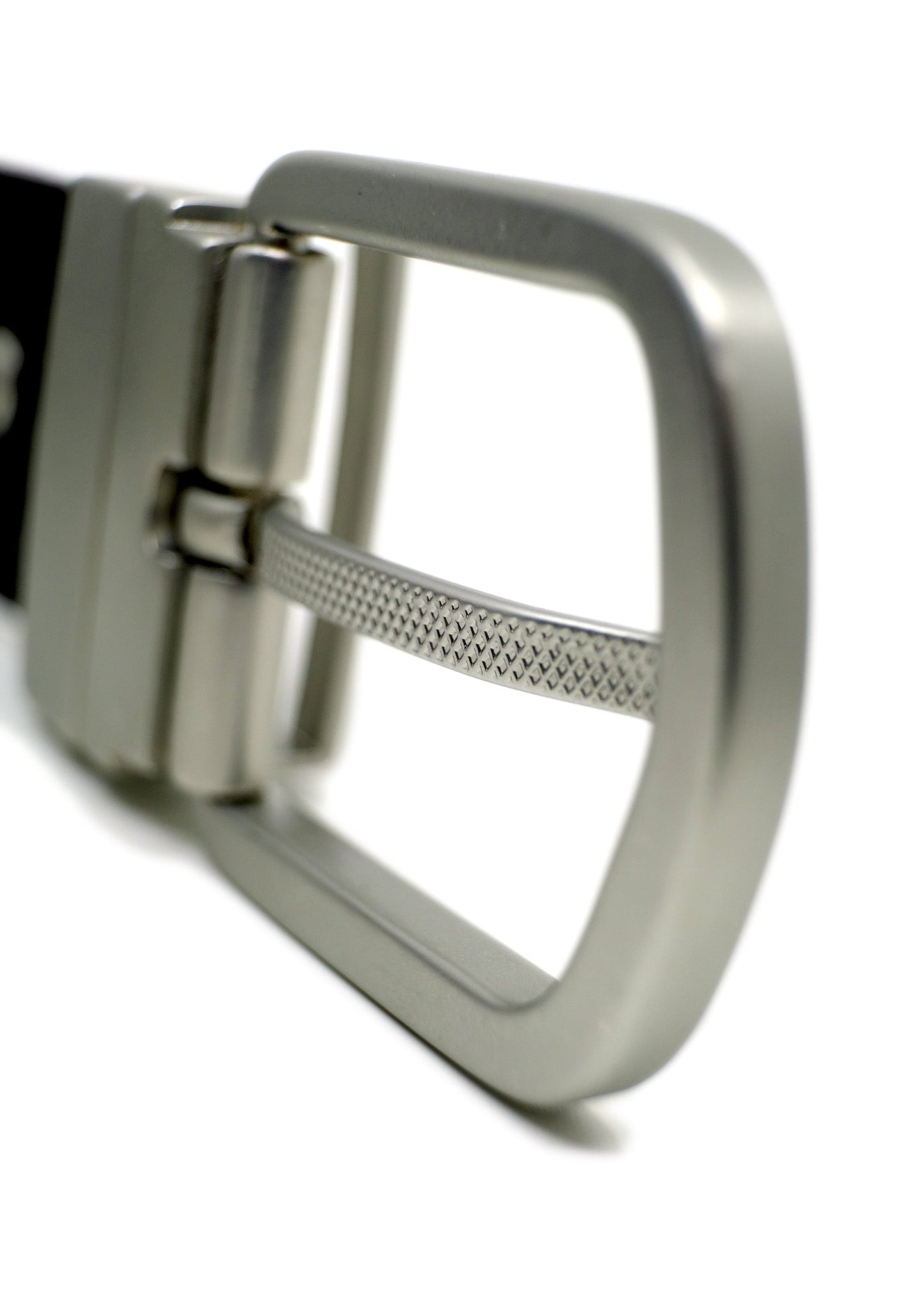 Macro shot of a reversible silver buckle with a patterned texture on the pin and a brushed metal finish.
