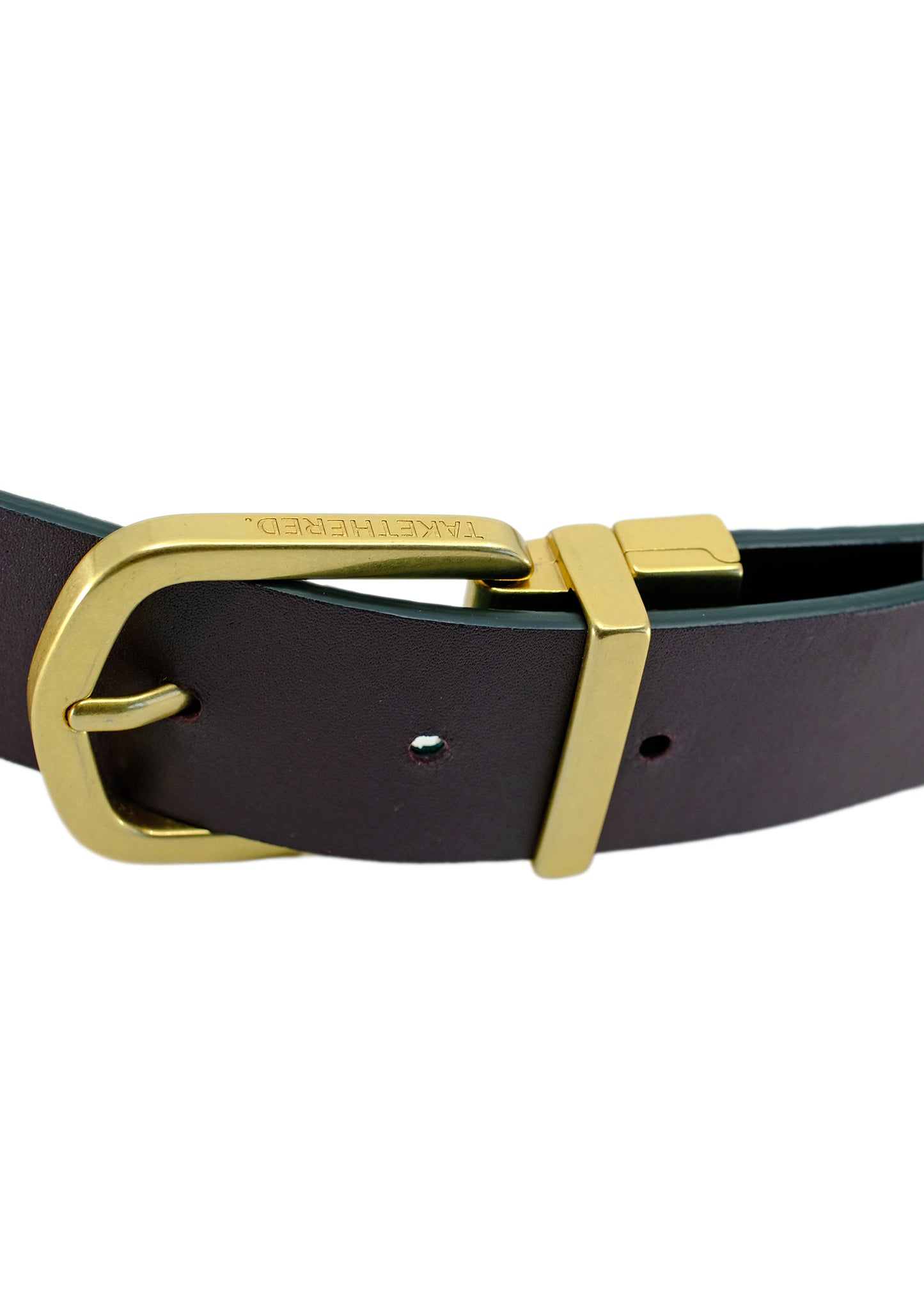 Detailed close-up of the Two-Face belt's reversible gold buckle fastened on the smooth Red Mist leather side, featuring the engraved logo.