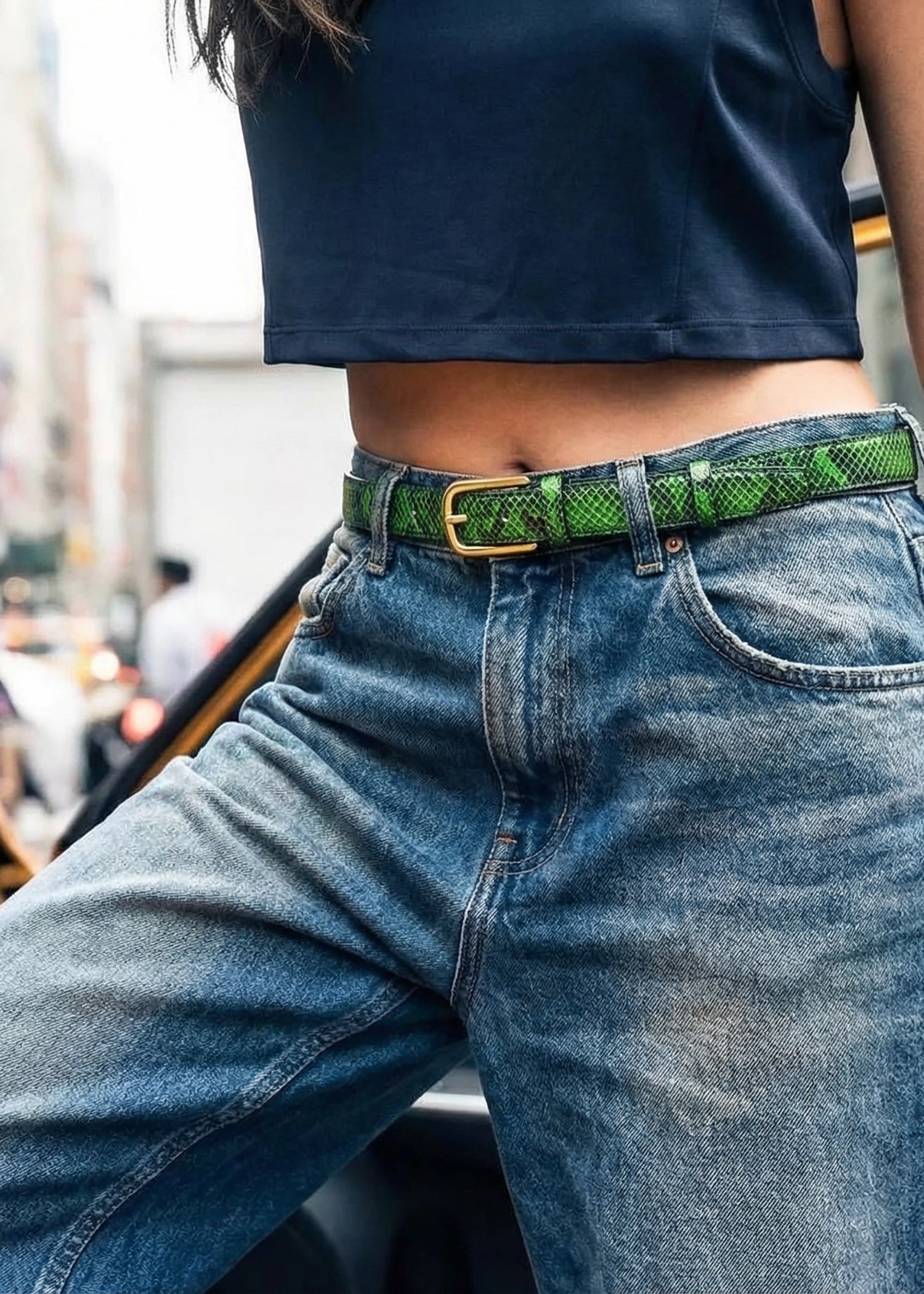 Atomic Green snakeskin belt with a gold buckle, worn on blue denim jeans for a vibrant urban look.