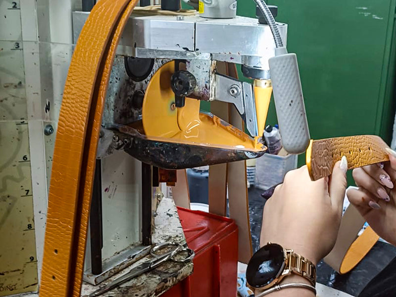 Detailed view of finishing the edges at belt production, making of a submarine yellow mississippi leather belt.