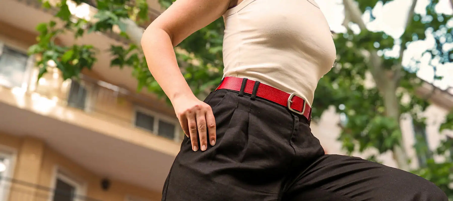 Lifestyle shot of a woman on the move wearing a blood red classic smooth leather belt with a silver buckle.