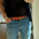 A customer is wearing a Tatooine sunset orange grunge belt with denim eans.