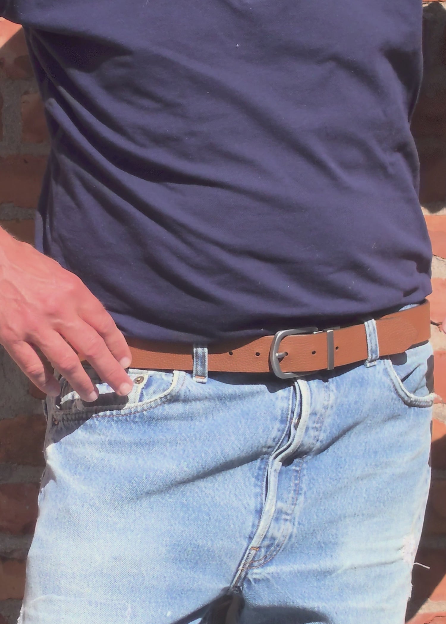 Lifestyle shot of the Two-Face Belt’s Smokey Cognac-grained side worn with light blue jeans and a navy t-shirt.